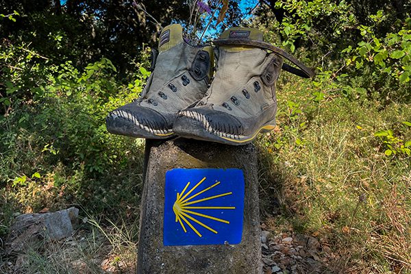 On the Camino Francés between Villatuerta and Los Arcos we came across a pair of old used walking boots that a pilgrim had left on a Camino waymarker
