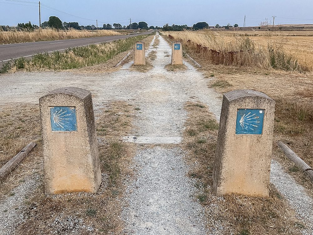 Camino Francés waymarkers along the long straight path across the Meseta