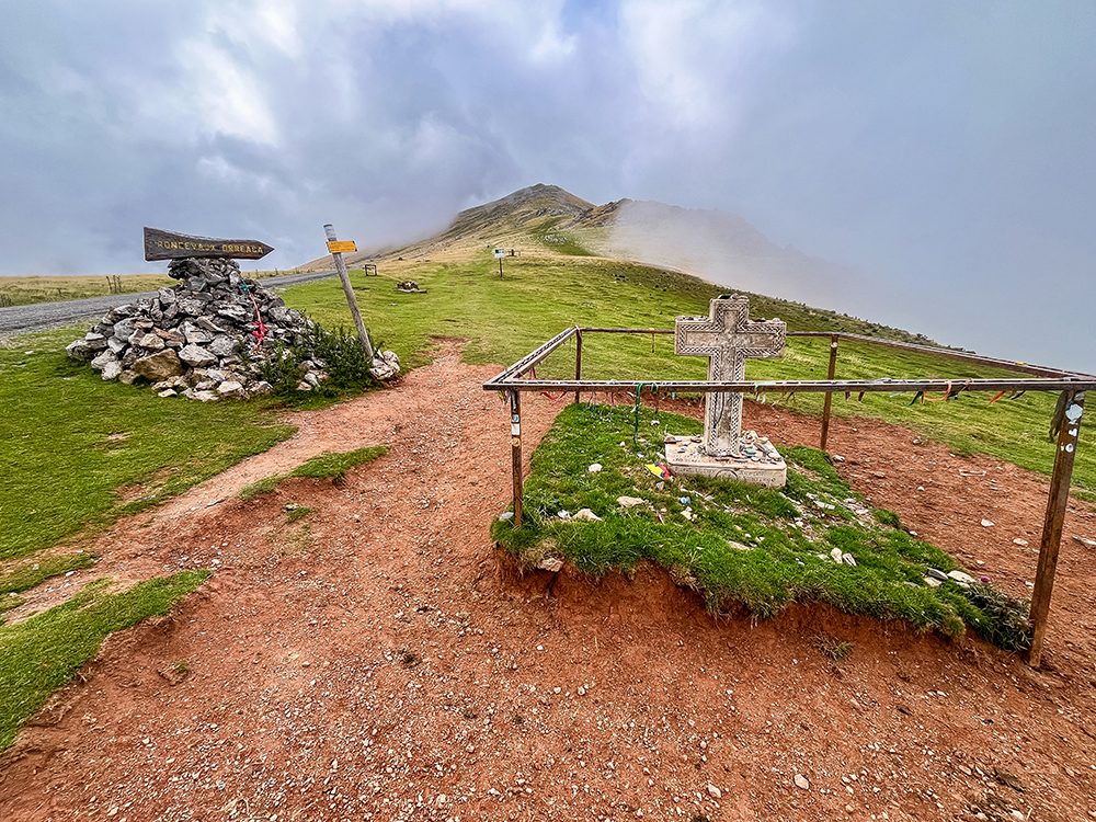 Stone cross and Camino waymarkers at Col de Lepoeder in the Pyrenees on the Camino Francés route to Roncesvalles.
