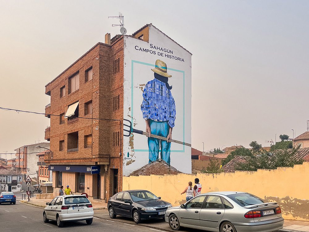 Campos de Historia mural depicting a farm worker on a building in Sahagún