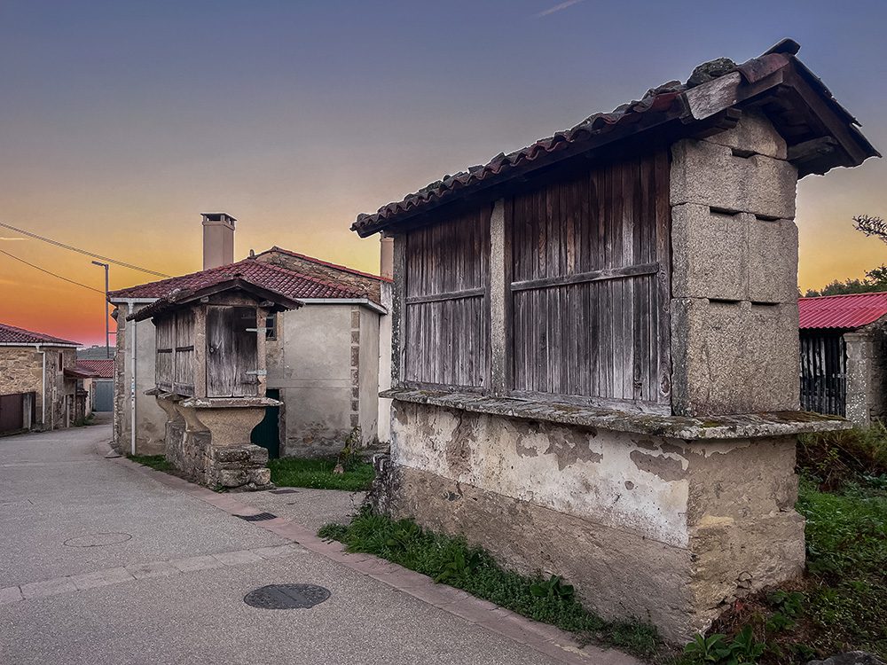 Traditional stone and wooden hórreos at sunrise in San Xulián on the Camino Francés in Galicia