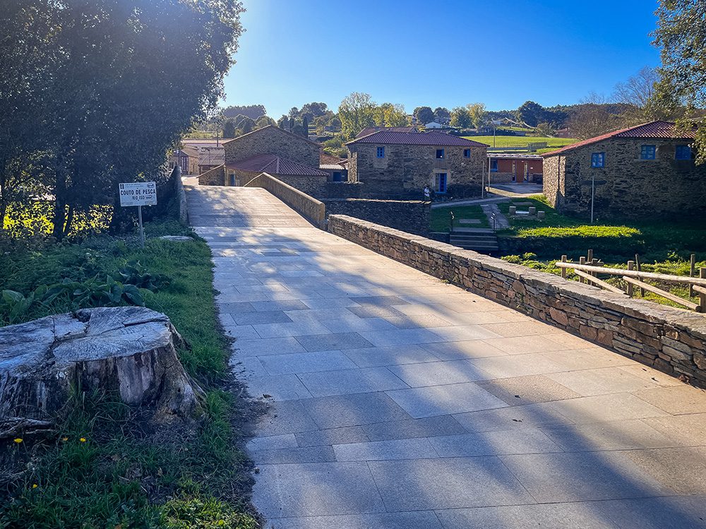 Medieval stone bridge and traditional stone buildings at Ribadiso de Baixo on the Camino Francés