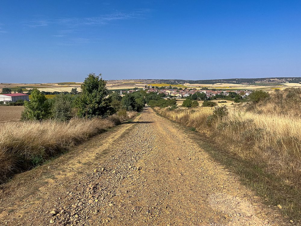 Camino Francés descending through the dry countryside towards Agés